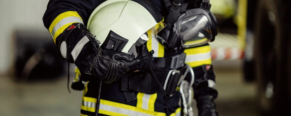Profissional usando vestimenta de proteção térmica com faixas refletivas e capacete, representando uniformes que atendem à NBR 13688 em ergonomia, mobilidade e conforto fisiológico em ambientes de risco térmico.