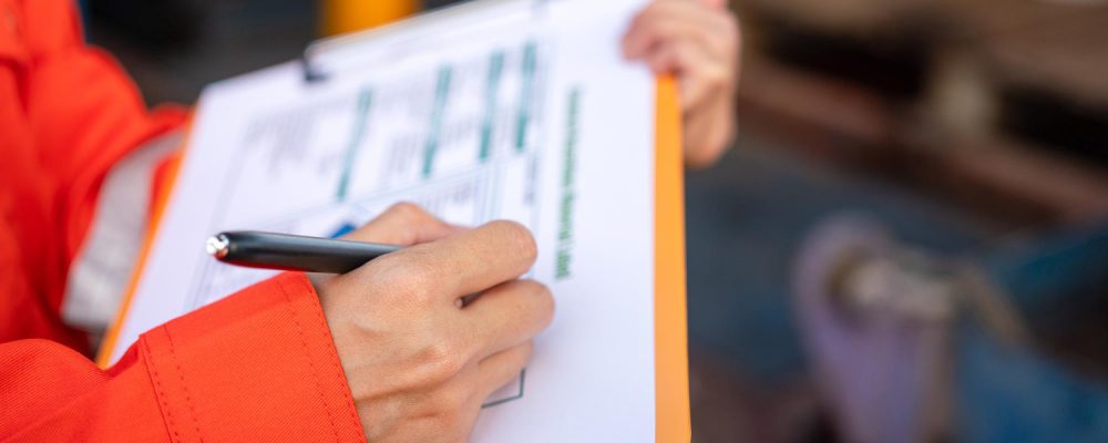 Profissional de segurança preenchendo formulário de inspeção em prancheta